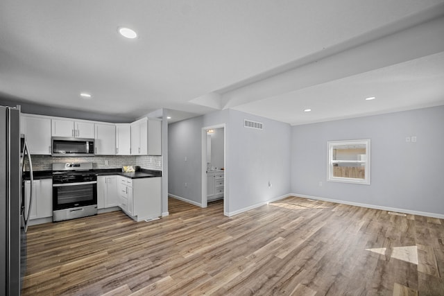 kitchen with backsplash, light hardwood / wood-style flooring, stainless steel appliances, and white cabinets