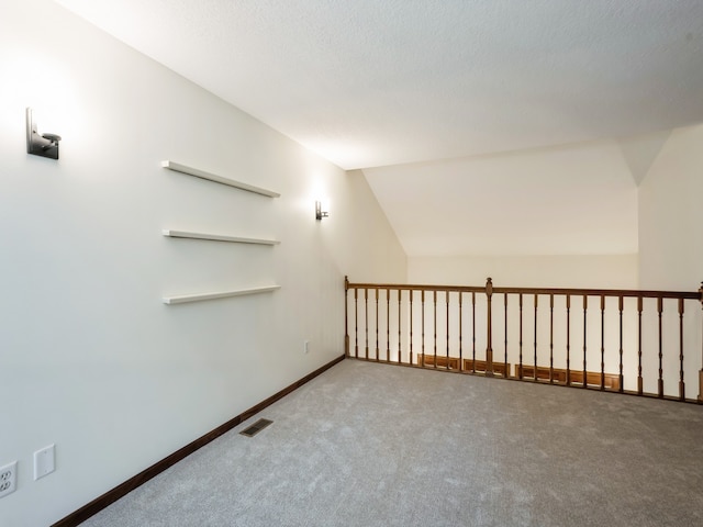 bonus room with a textured ceiling, lofted ceiling, and carpet flooring