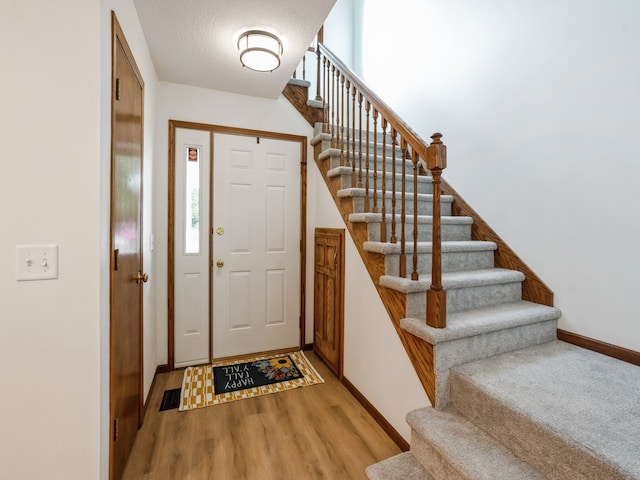 entrance foyer with light wood-type flooring and a textured ceiling