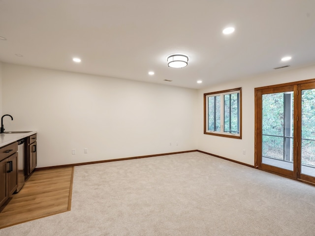 interior space featuring light colored carpet, sink, and stainless steel dishwasher