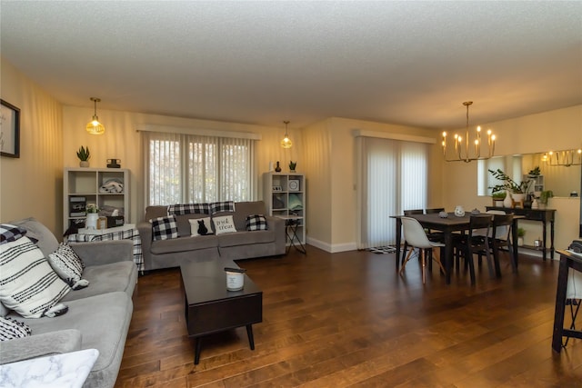 living room with a notable chandelier, dark hardwood / wood-style floors, and a textured ceiling