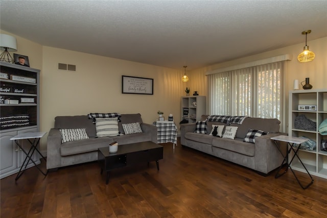 living room with dark wood-type flooring and a textured ceiling