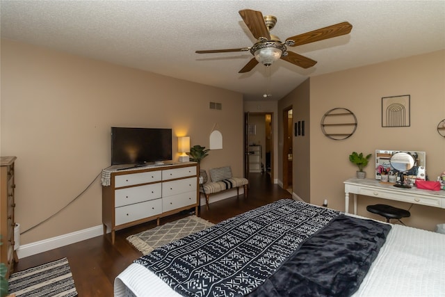 bedroom with a textured ceiling, ceiling fan, and dark hardwood / wood-style flooring