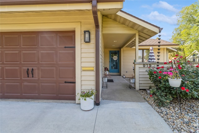 doorway to property featuring a garage and a porch