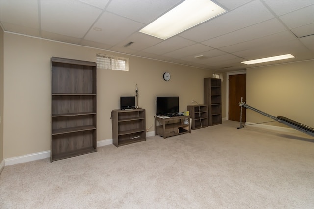 basement featuring a drop ceiling and light colored carpet