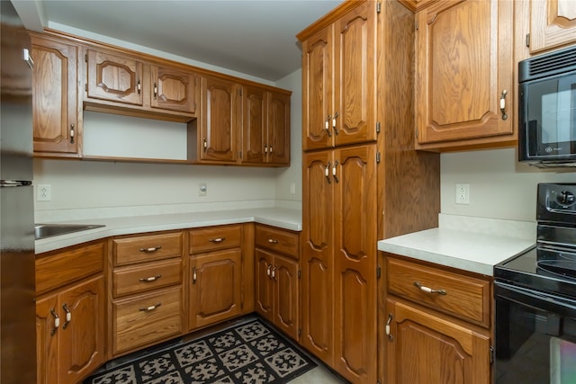 kitchen with light tile patterned flooring, sink, and black appliances