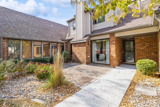 view of exterior entry with a patio