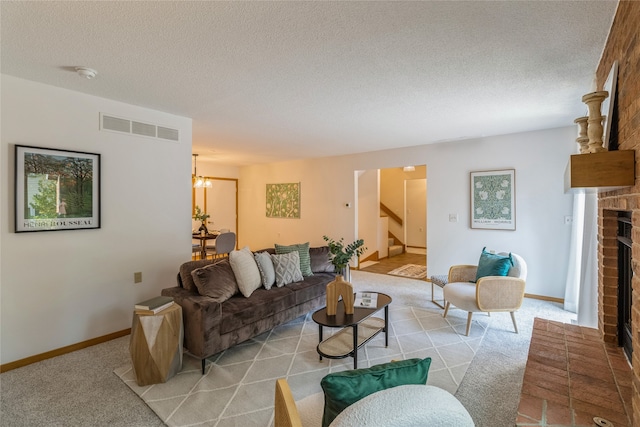 living room featuring a fireplace, light carpet, a textured ceiling, and a notable chandelier