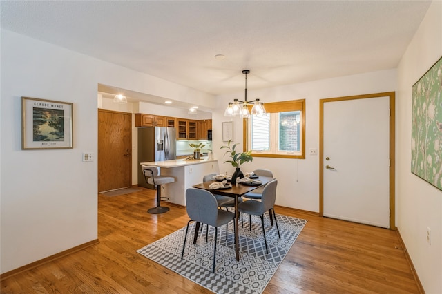 dining space featuring a chandelier and light hardwood / wood-style flooring