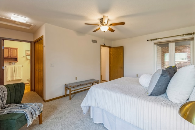 carpeted bedroom with ensuite bath and ceiling fan