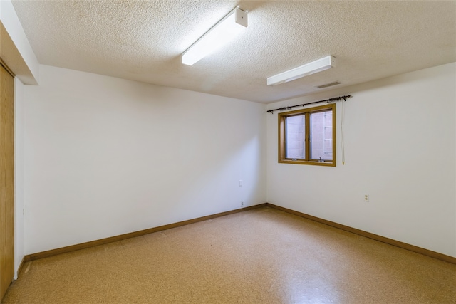 unfurnished room featuring a textured ceiling