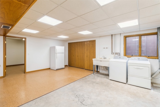 clothes washing area with washing machine and dryer and sink