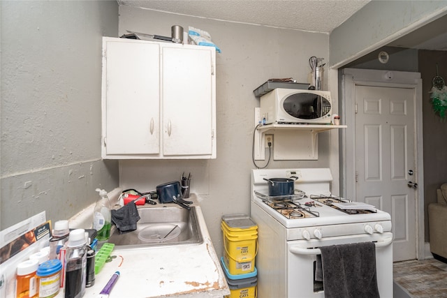 kitchen with white cabinets, a textured ceiling, sink, and white appliances