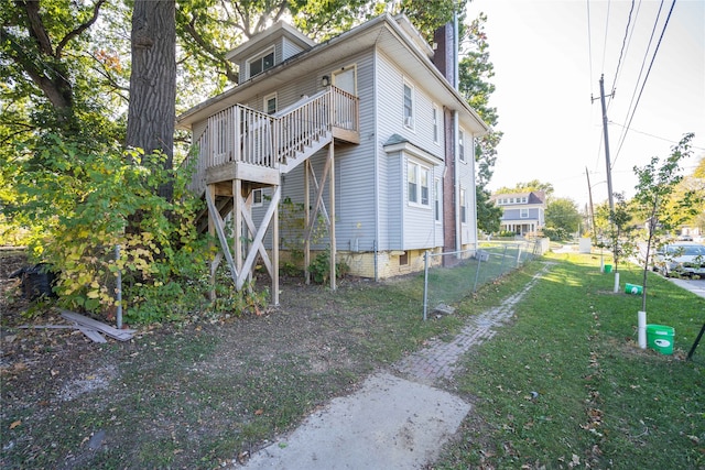 view of property exterior featuring a wooden deck and a yard