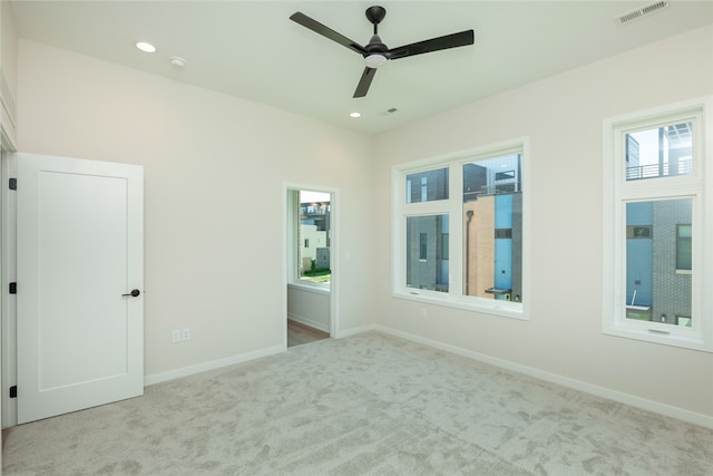 carpeted spare room featuring ceiling fan