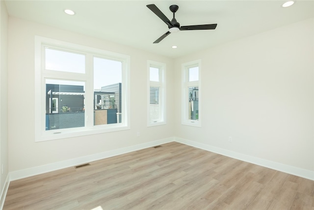 empty room featuring ceiling fan, light hardwood / wood-style floors, and a healthy amount of sunlight