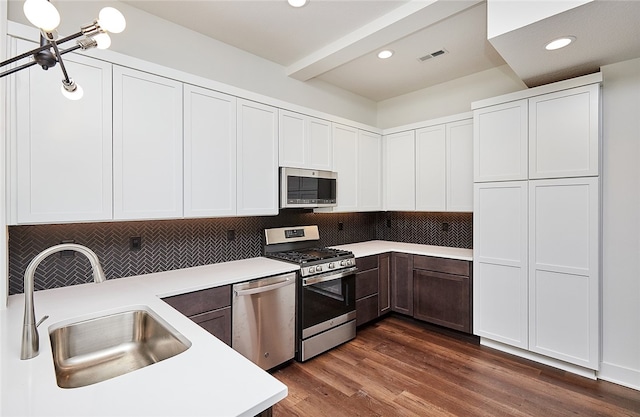 kitchen with white cabinets, stainless steel appliances, and dark hardwood / wood-style flooring