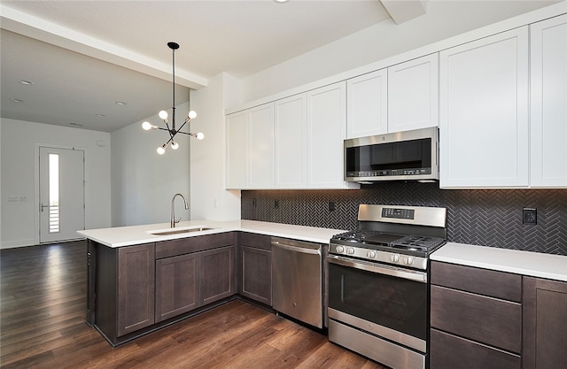 kitchen featuring decorative light fixtures, white cabinetry, stainless steel appliances, and dark hardwood / wood-style flooring