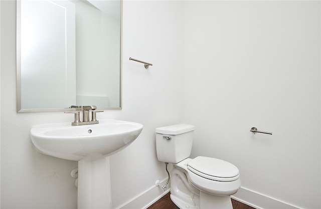 bathroom with hardwood / wood-style flooring and toilet