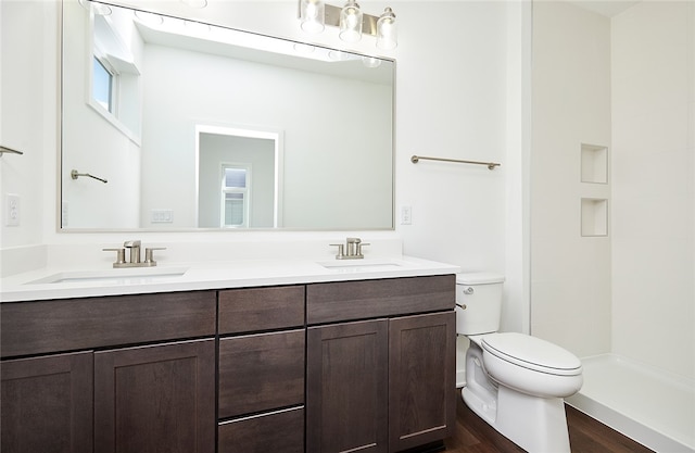 bathroom with walk in shower, vanity, hardwood / wood-style floors, and toilet