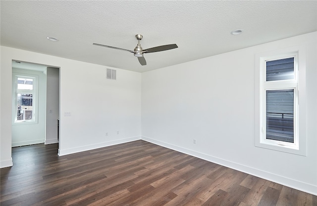 spare room featuring dark wood-type flooring and a textured ceiling