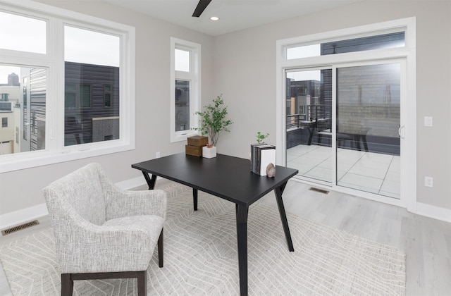 home office with light wood-type flooring and ceiling fan