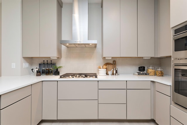 kitchen featuring white cabinetry, backsplash, stainless steel gas stovetop, and extractor fan