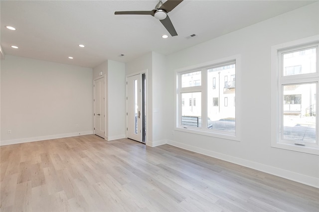 empty room with ceiling fan, light hardwood / wood-style flooring, and a wealth of natural light