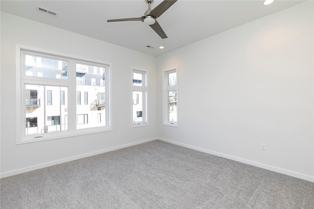 carpeted spare room with plenty of natural light and ceiling fan