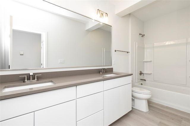 full bathroom featuring hardwood / wood-style floors, vanity, toilet, and shower / washtub combination