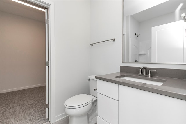 bathroom with walk in shower, vanity, and toilet