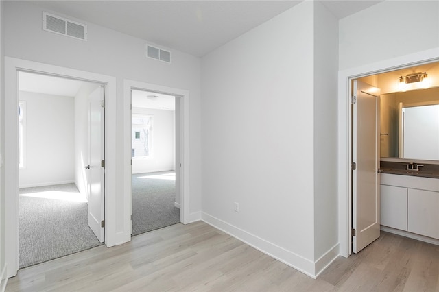 hall with light wood-type flooring and sink