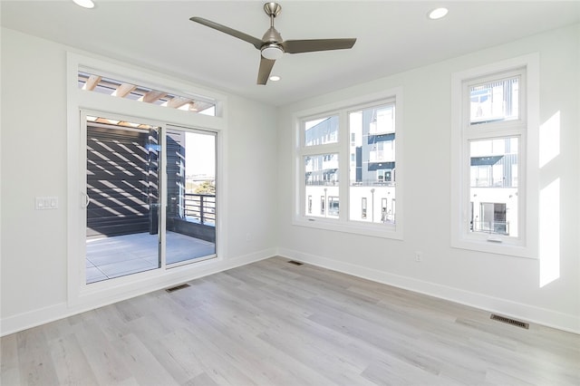 unfurnished room featuring ceiling fan, light hardwood / wood-style floors, and a healthy amount of sunlight