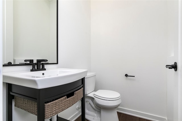 bathroom featuring vanity, hardwood / wood-style flooring, and toilet