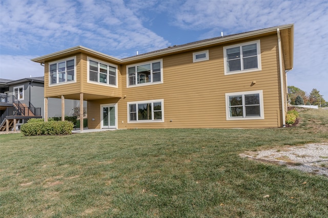 rear view of house with a wooden deck and a lawn