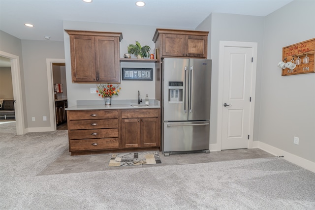 kitchen with light carpet, sink, and stainless steel fridge with ice dispenser