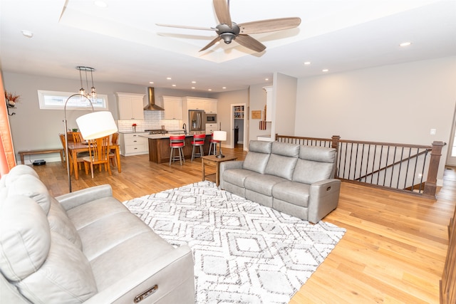 living room featuring light hardwood / wood-style flooring and ceiling fan