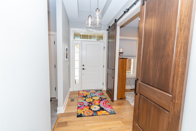 entrance foyer with light wood-type flooring and a barn door