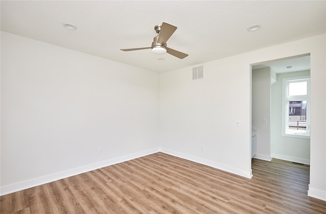 empty room featuring ceiling fan, hardwood / wood-style floors, and a textured ceiling