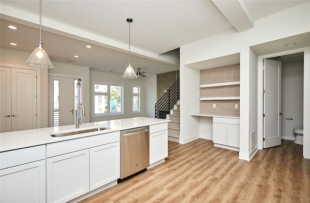 kitchen featuring dishwasher, light hardwood / wood-style flooring, pendant lighting, and sink