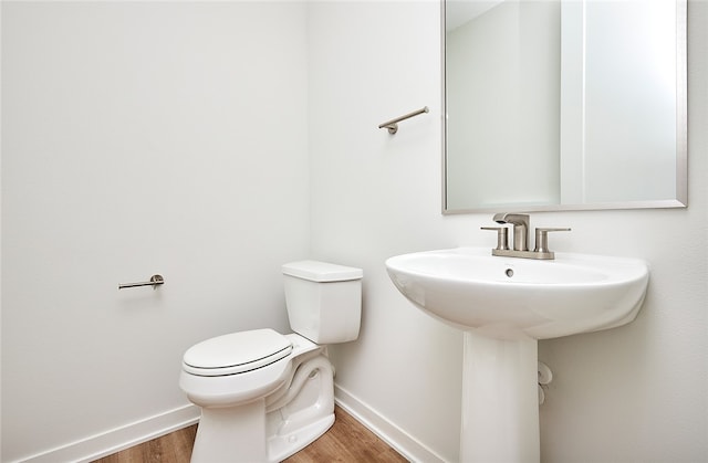 bathroom with hardwood / wood-style floors and toilet