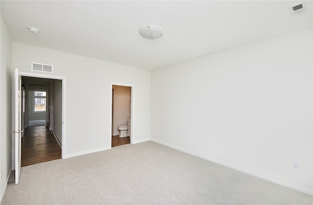 unfurnished bedroom with carpet floors and connected bathroom