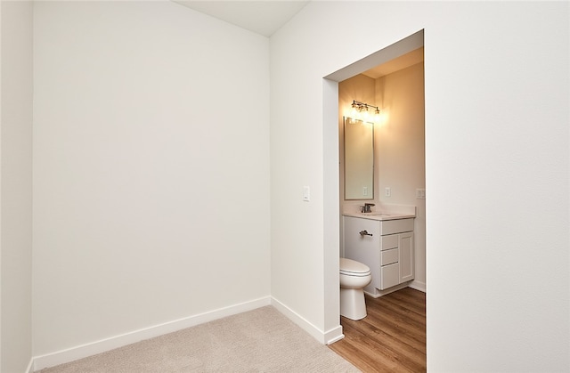 bathroom featuring vanity, toilet, and hardwood / wood-style flooring