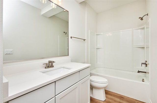 full bathroom with hardwood / wood-style floors, bathtub / shower combination, vanity, and toilet