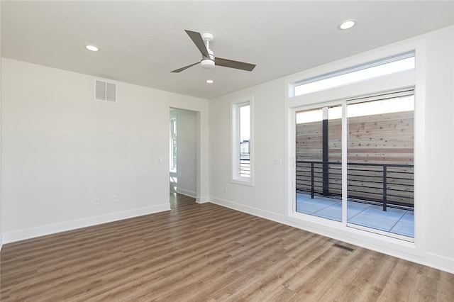 unfurnished room featuring ceiling fan, a wealth of natural light, and wood-type flooring