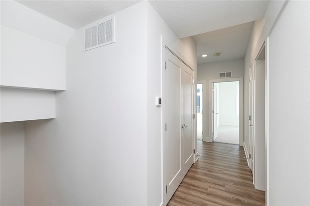 hall featuring hardwood / wood-style floors and a textured ceiling