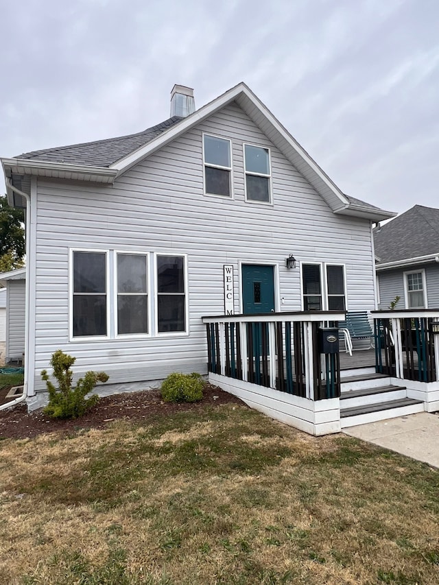 rear view of property with a lawn and a wooden deck