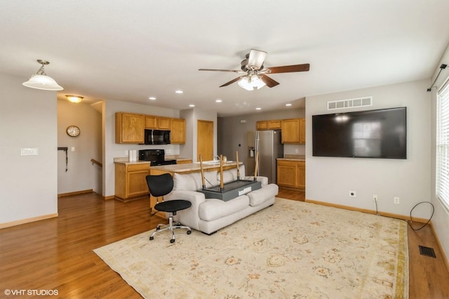 living room featuring dark wood-type flooring and ceiling fan