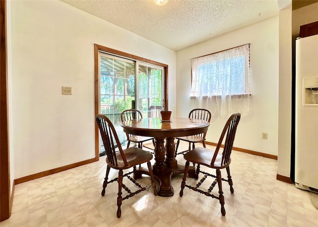 dining space featuring a textured ceiling