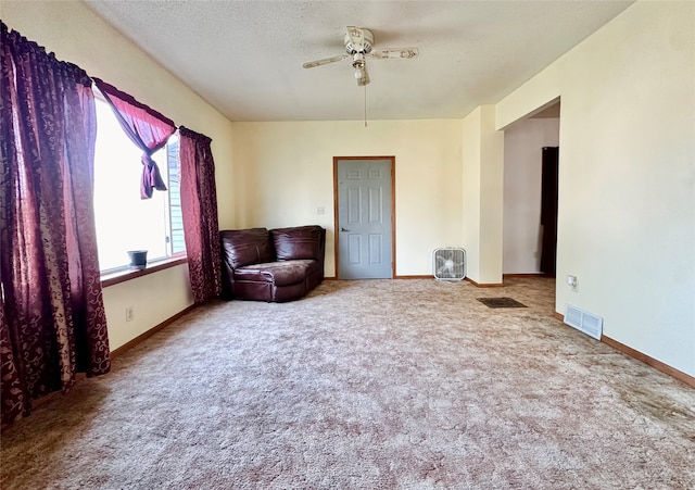 unfurnished room featuring ceiling fan, carpet, and a textured ceiling